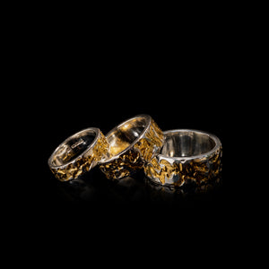 Camo Mens & Womens Sterling Silver Gold Rings Shining On Black Glossy Background.