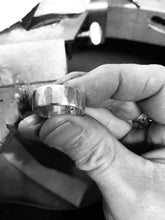 Load image into Gallery viewer, Solo Men&#39;s Handmade Textured Sterling Silver Ring Being Held In Jewellers Dirty Fingers At Workbench.