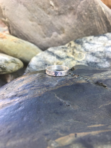 Sparkle Sterling Silver Hammered Texture Ladies' Ring Band Sat Upon Rocks At Porthmeor Beach St. Ives Cornwall.