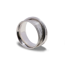 Load image into Gallery viewer, Planished hammered texture ladies spinner ring standing on edge with a bright white background.