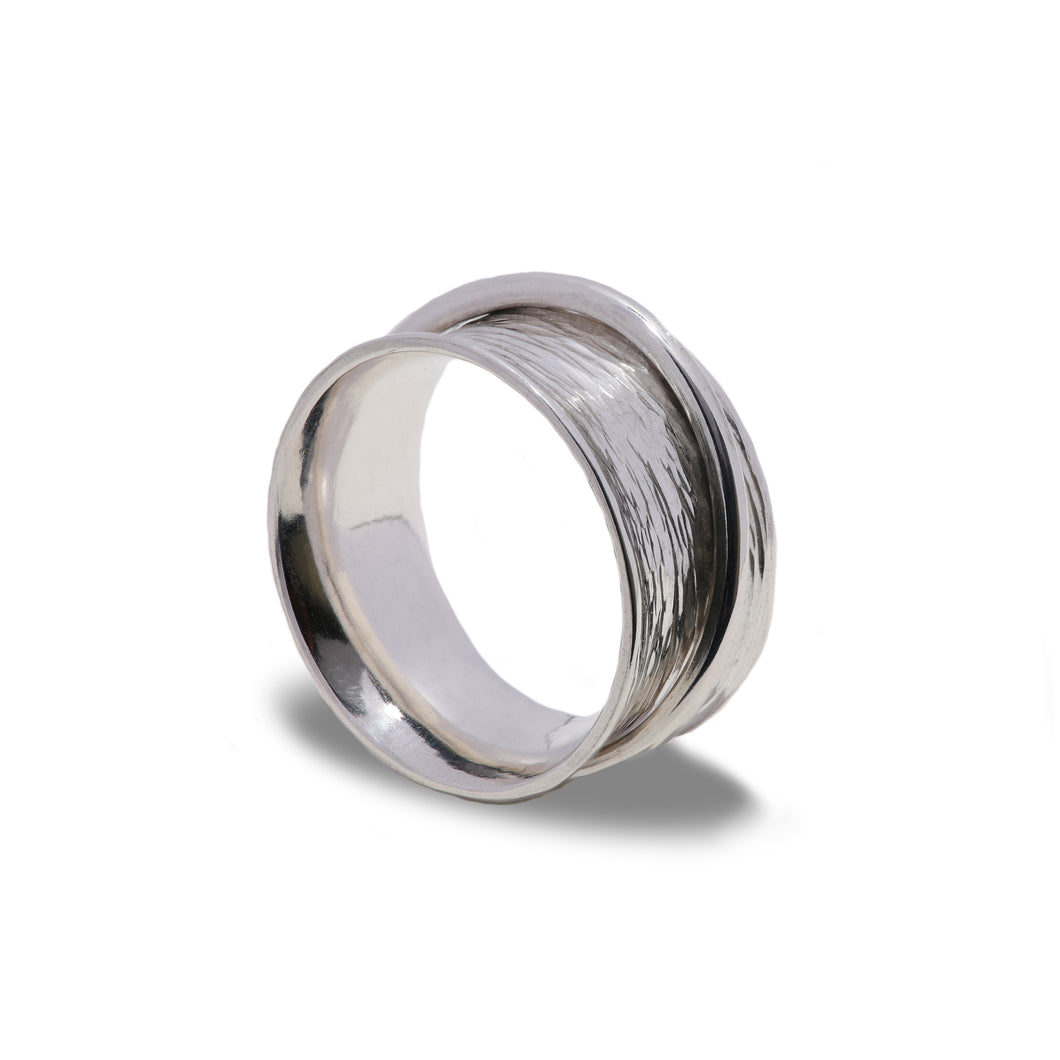 Planished hammered texture ladies spinner ring standing on edge with a bright white background.